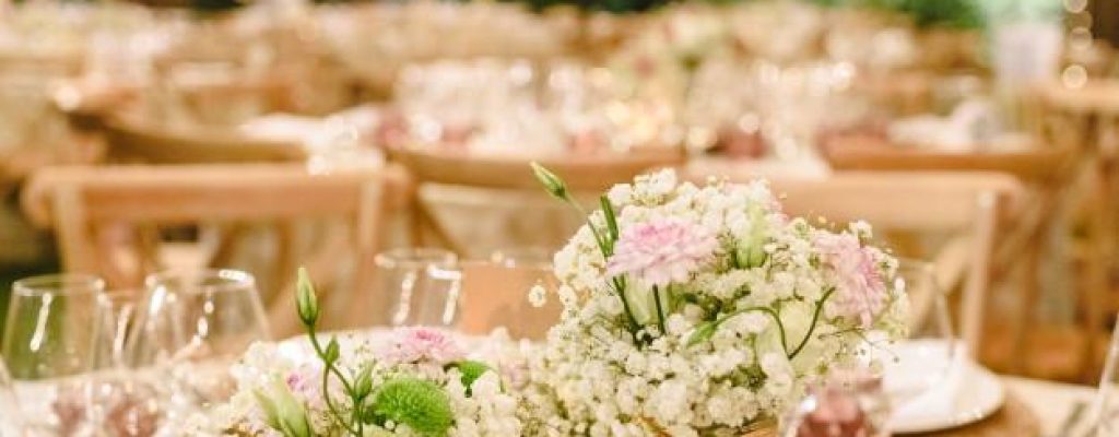 flores-que-decoran-centros-mesa-cubiertos-lujo-mesas-salon-bodas_47726-6006